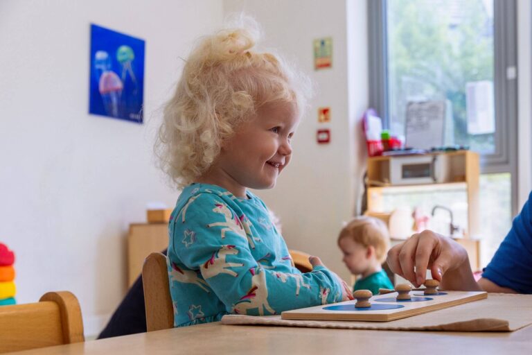 Child Smiling While Playing with a Montessori Toy Indoors