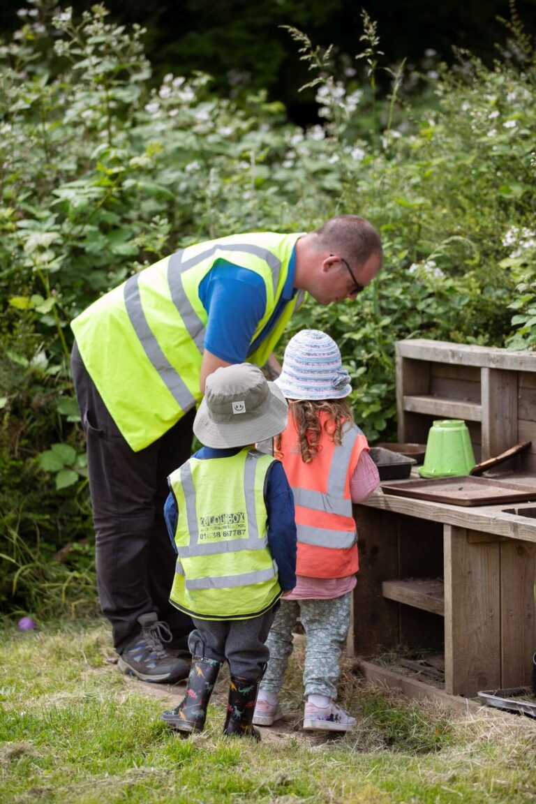 Children Engaged in an Outdoor Activity with Nursery Nurse