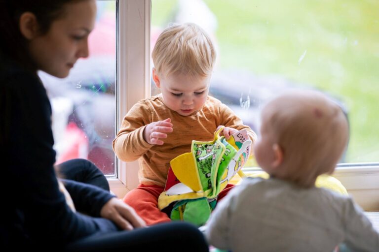 Toddlers Playing with a Nursery Nurse