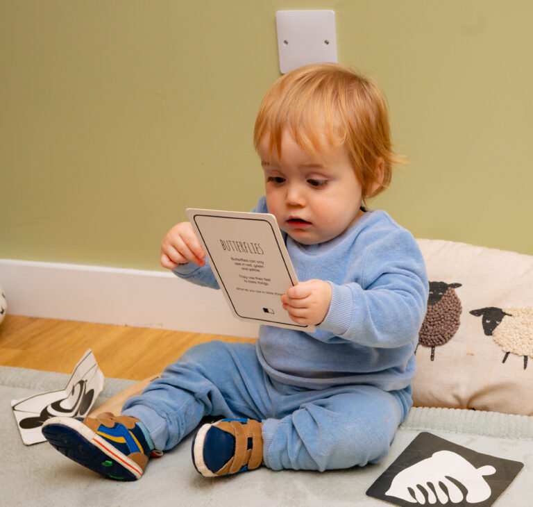 Baby Exploring Picture Cards in Nursery